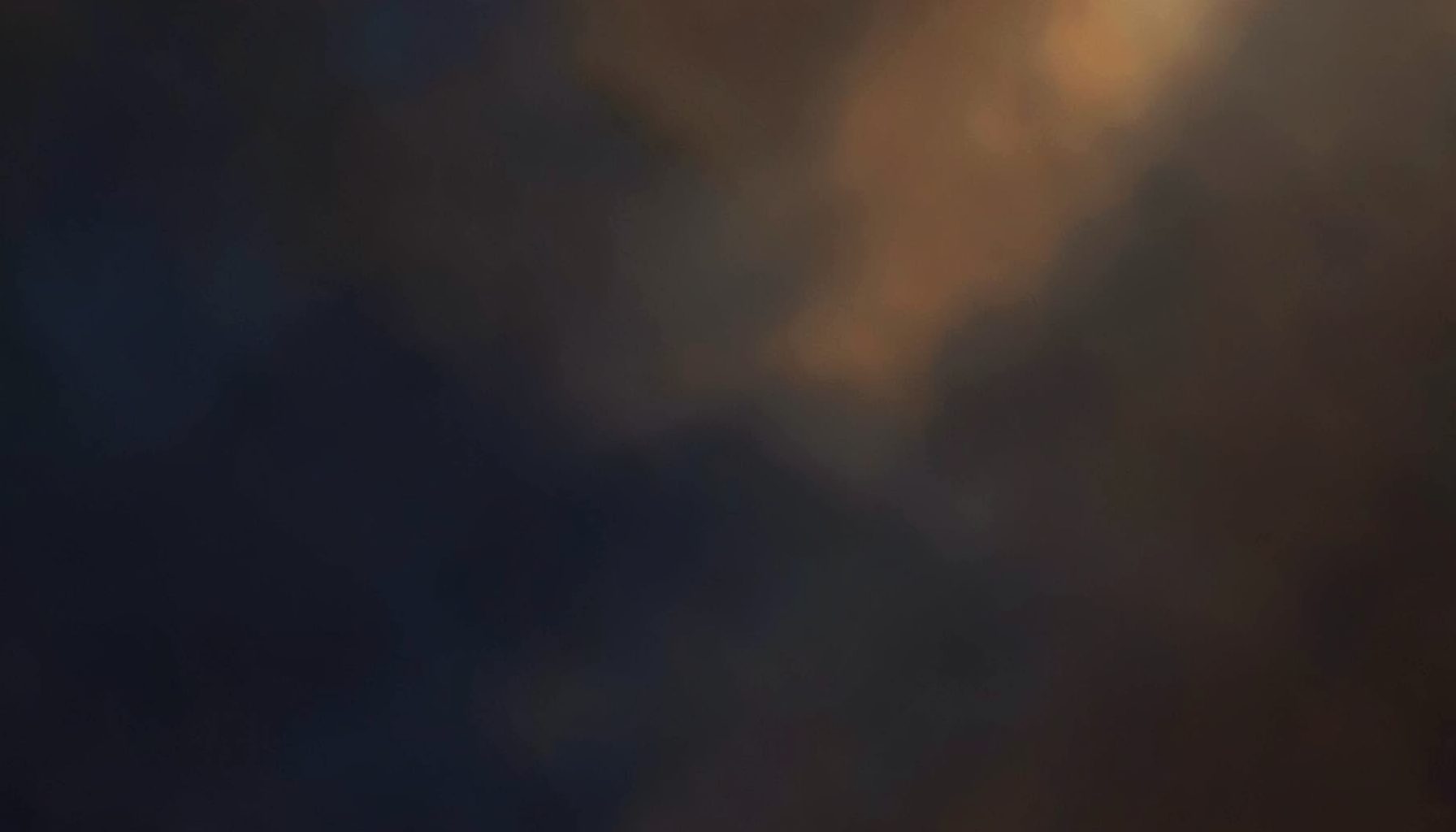 Warm abstract background with deep navy and charcoal hues accented by soft amber light